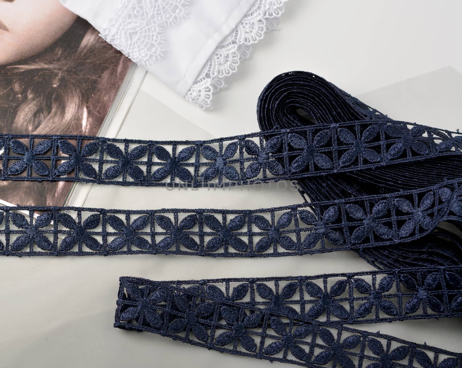 Tapes of blue gentle guipure, beauty silk lace fabric on light background. Elastic material. Using for Atelier and needlework store. Flat lay style