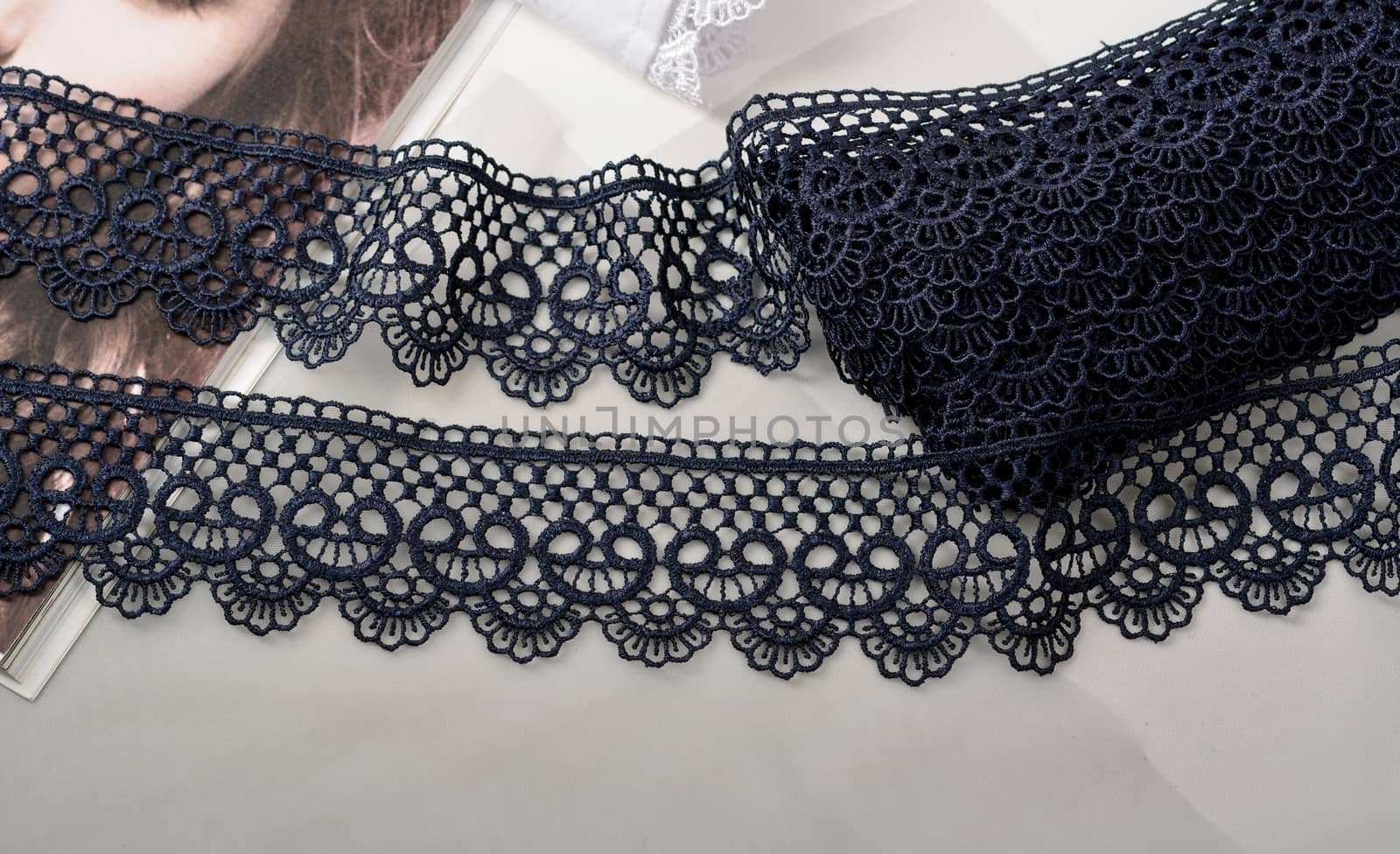 Tapes of blue gentle guipure, beauty silk lace fabric on light background. Elastic material. Using for Atelier and needlework store. Flat lay style