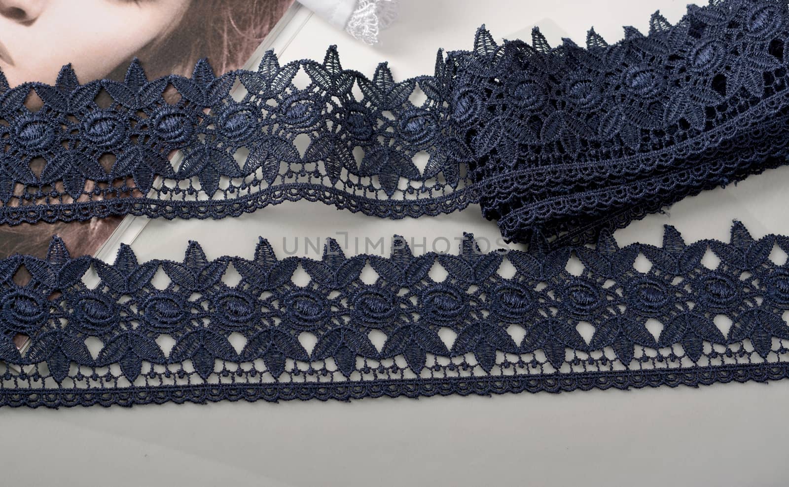 Tapes of blue gentle guipure, beauty silk lace fabric on light background. Elastic material. Using for Atelier and needlework store. Flat lay style