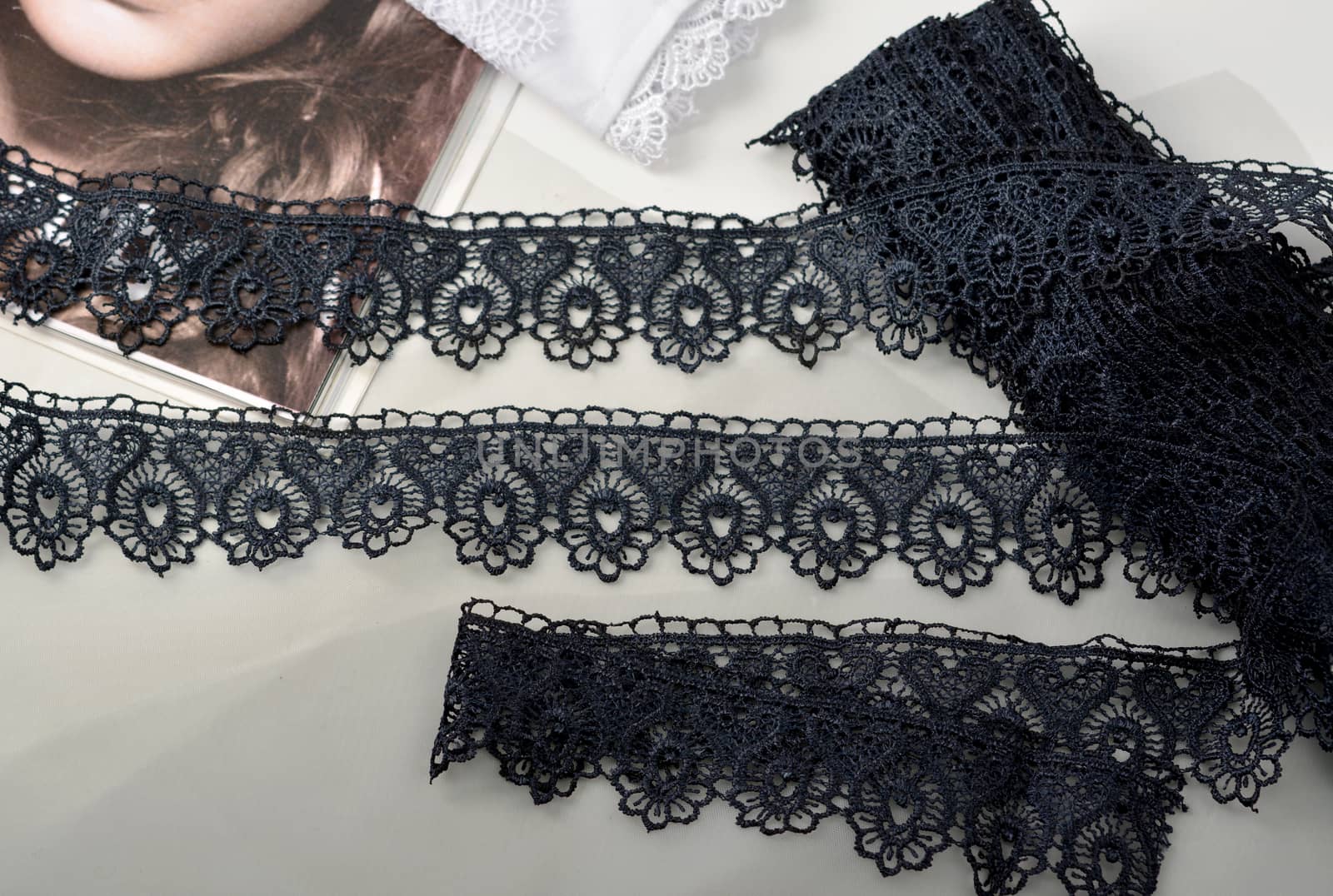 Tapes of blue gentle guipure, beauty silk lace fabric on light background. Elastic material. Using for Atelier and needlework store. Flat lay style