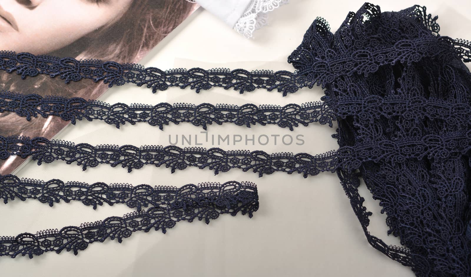 Tapes of blue gentle guipure, beauty silk lace fabric on light background. Elastic material. Using for Atelier and needlework store. Flat lay style