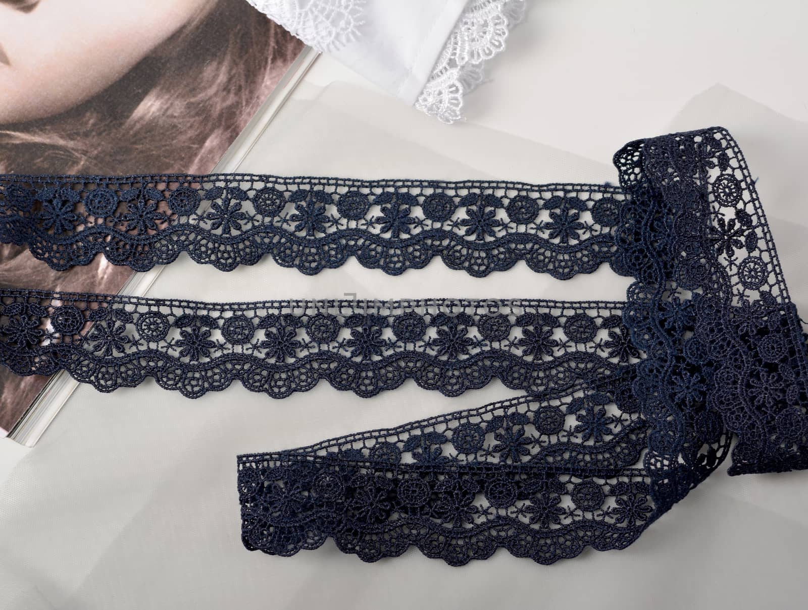 Tapes of blue gentle guipure, beauty silk lace fabric on light background. Elastic material. Using for Atelier and needlework store. Flat lay style