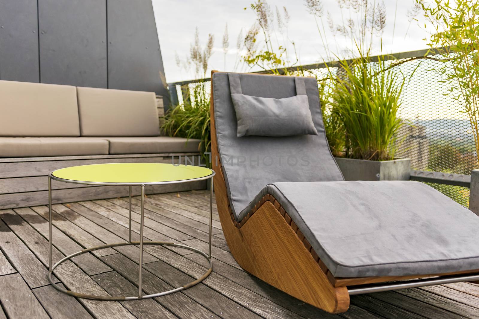 Rocking lounger on a roof terrace with bamboo and grasses by Umtsga