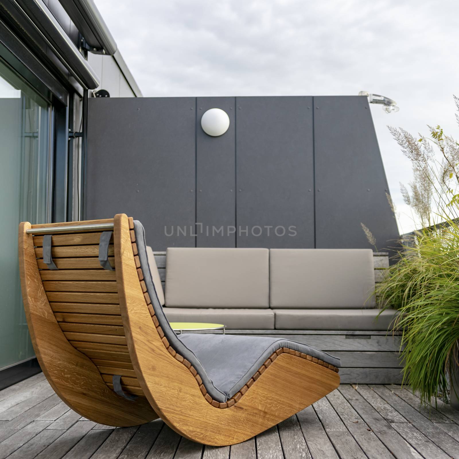 Rocking lounger on a roof terrace with bamboo and grasses by Umtsga