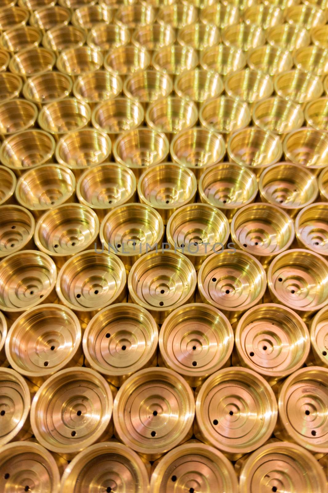 an abstract perspective industrial close-up background of shiny brass metal threaded hexagonal fitting parts.