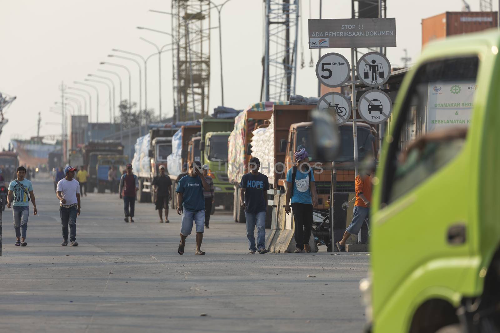 Boats, goods and workers in the port of the city of Jakarta by alvarobueno