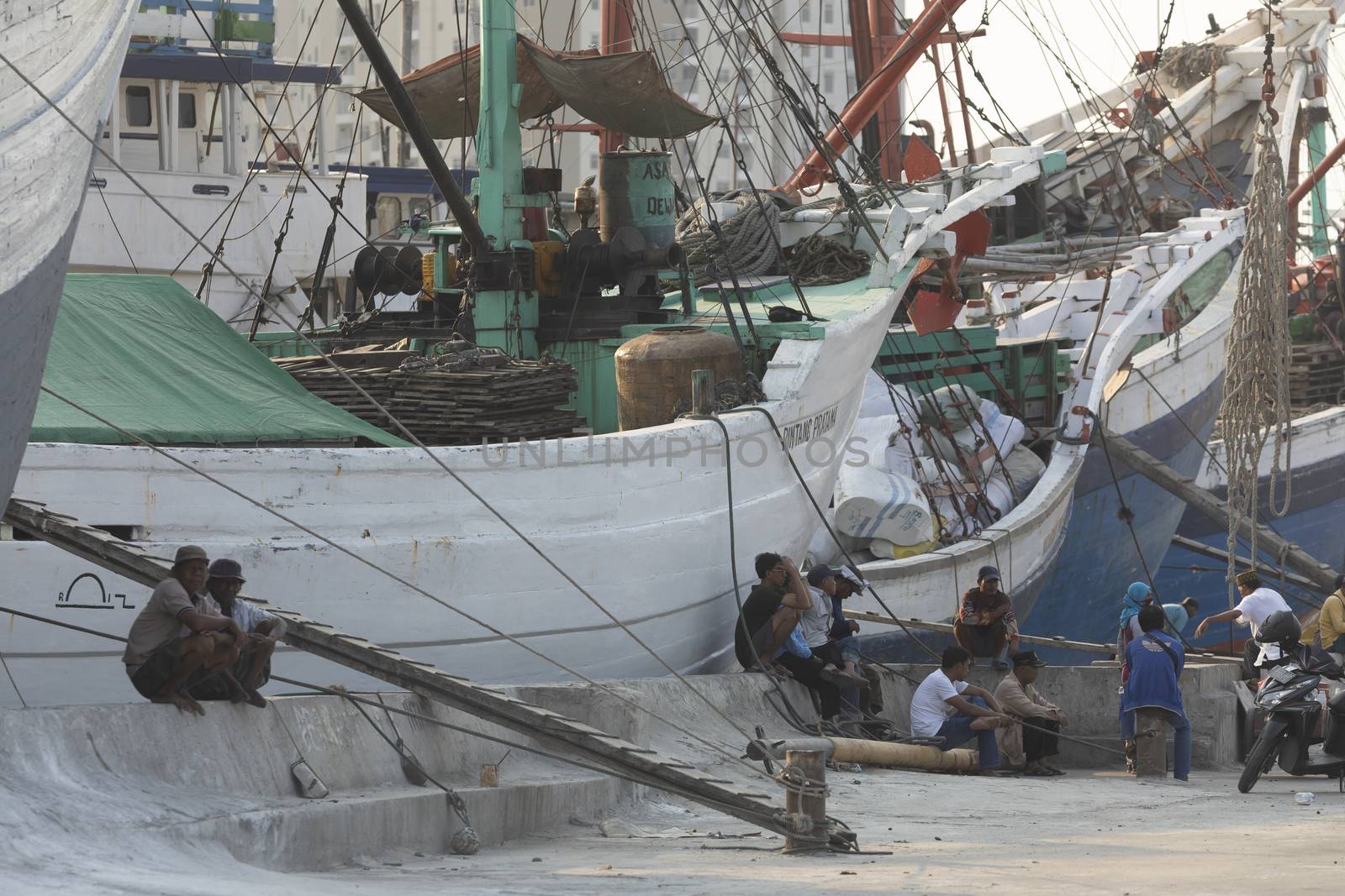 Boats, goods and workers in the port of the city of Jakarta by alvarobueno