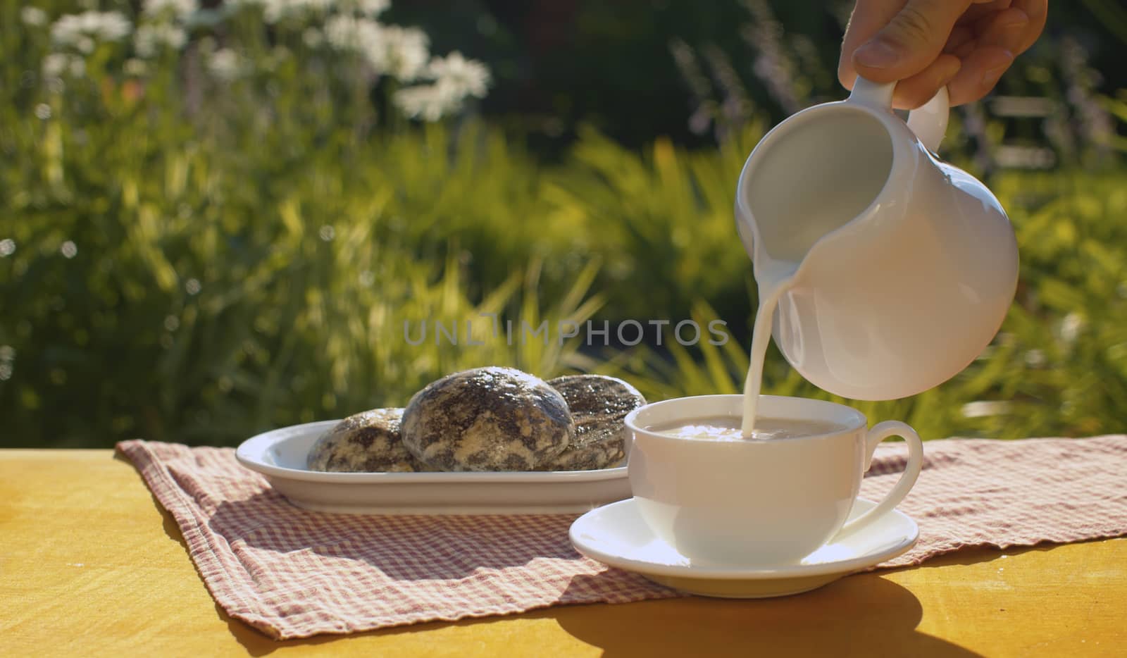 Adding milk into a cup of coffee by Alize