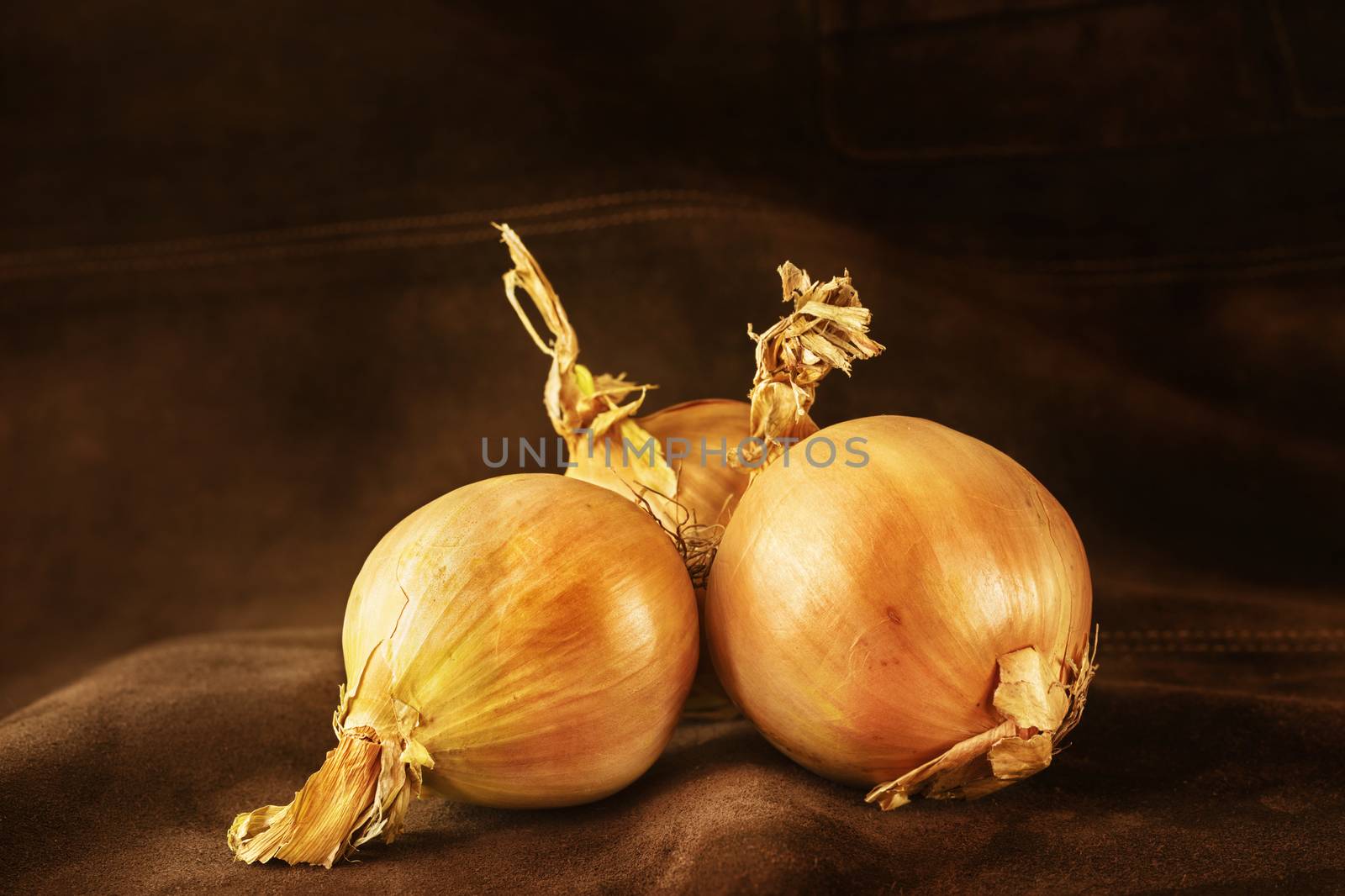 Brown onions on dark brown background ,whole common onions ,