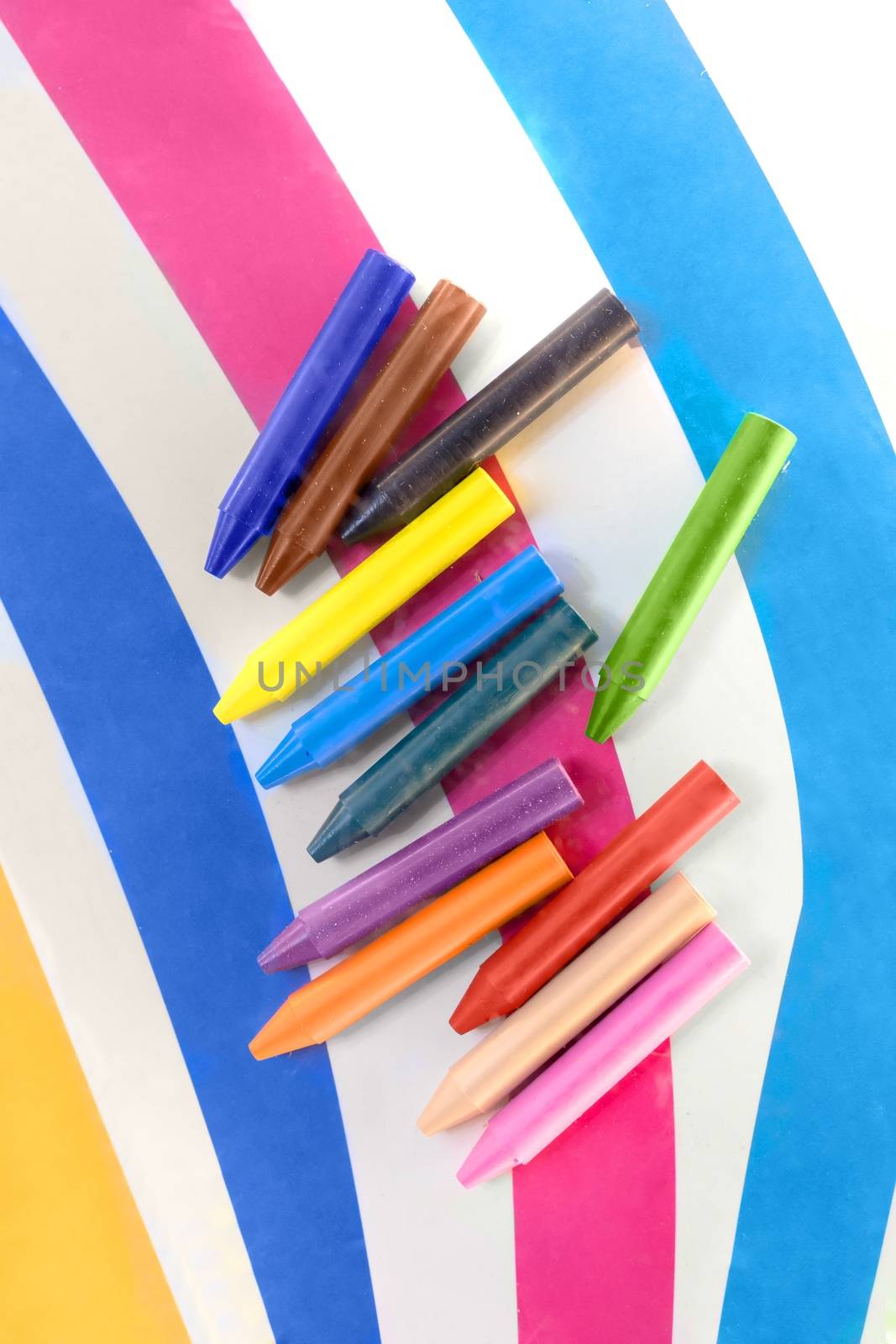 Colorful crayons against linear background closeup photo