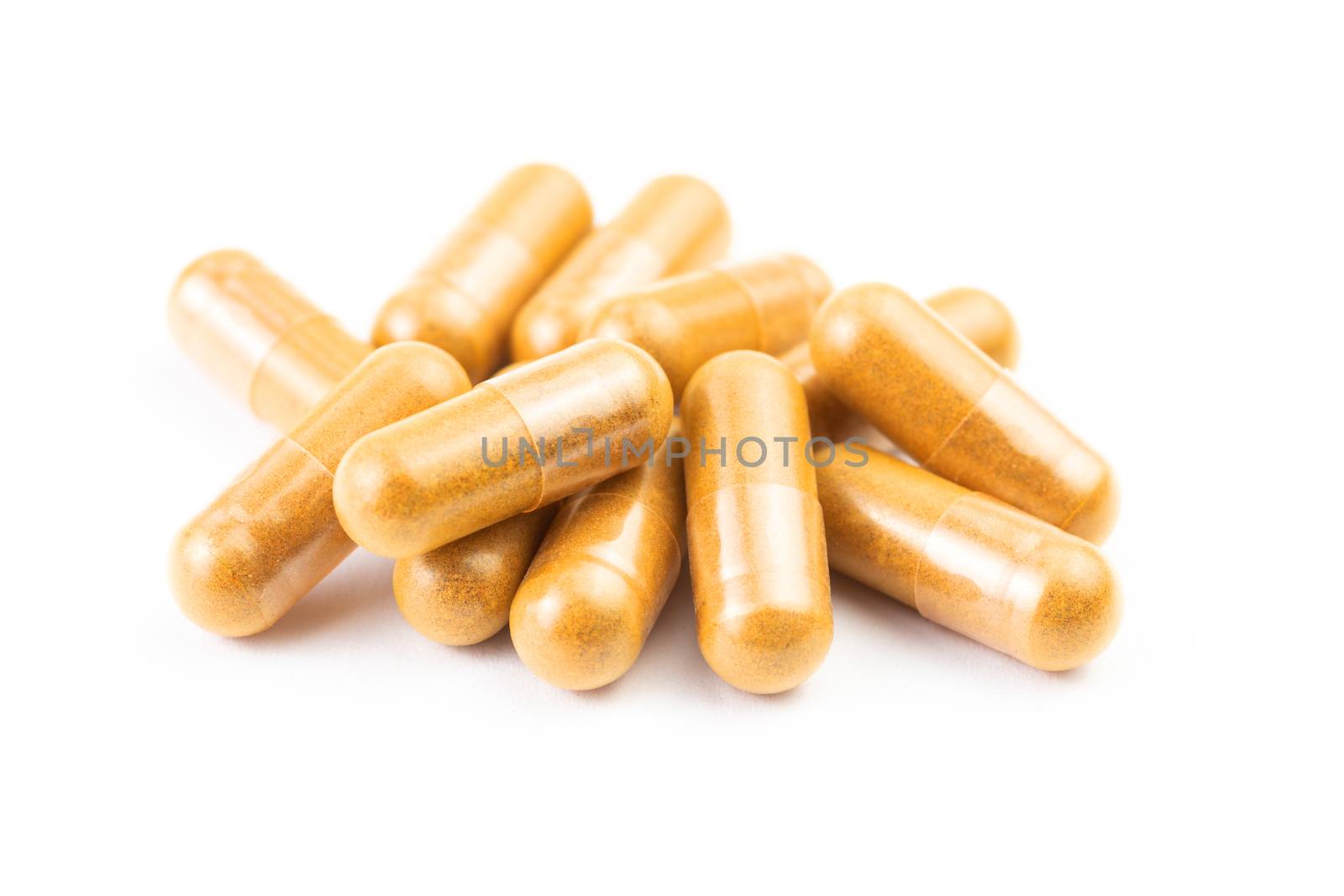 pile of orange organic capsules isolated on white background closeup with selective focus.