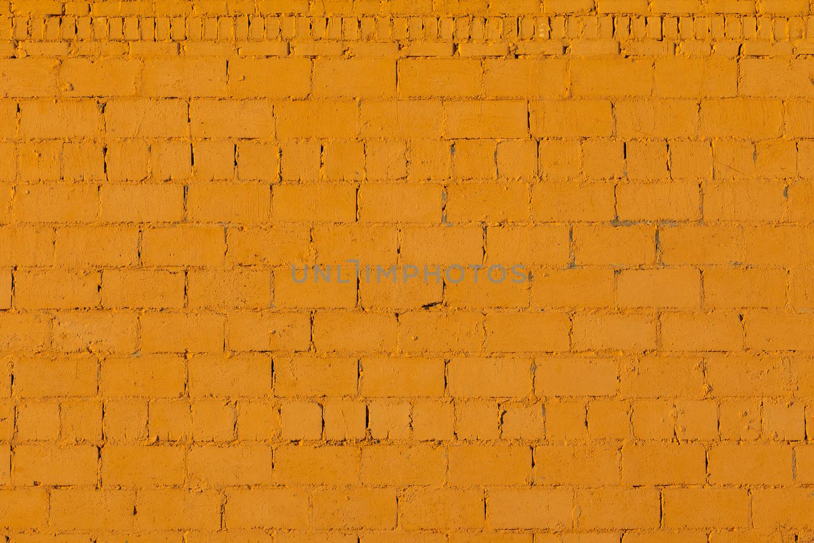 orange plaster rough brick wall texture under direct sunlight