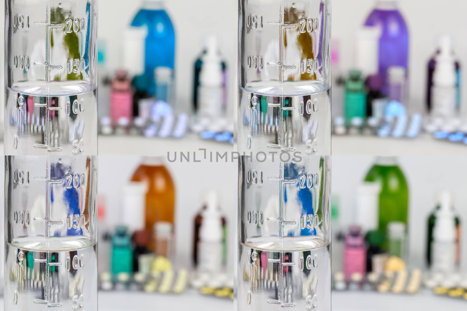 set of measuring bottle glass bottle with colorless liquid on blurred meds background with selective focus.