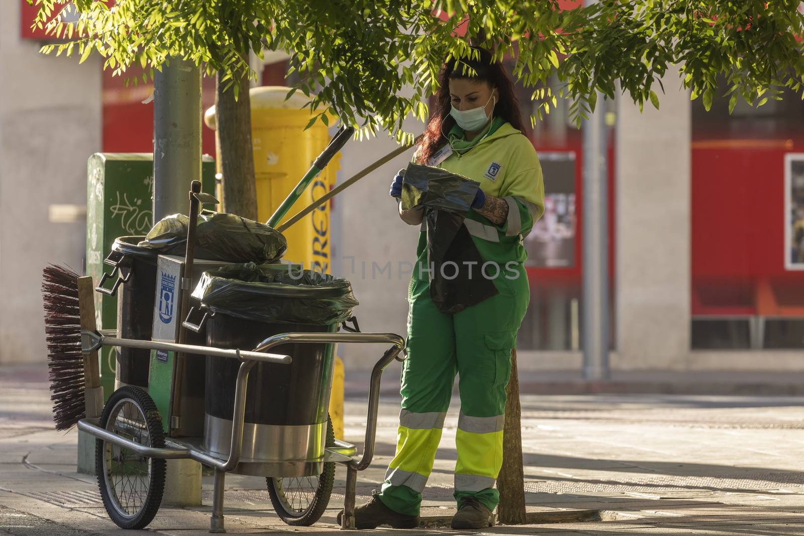 A worker in her daily cleaning tasks in Madrid by alvarobueno