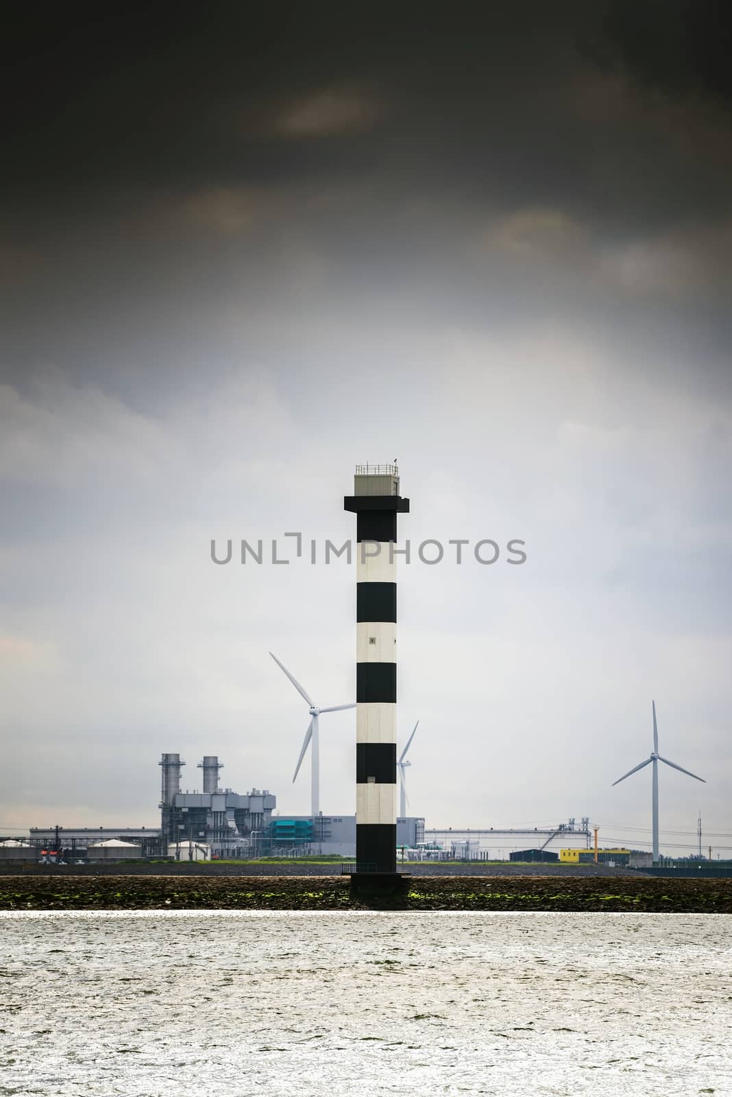 Industrial lighthouse standing on the factory shore