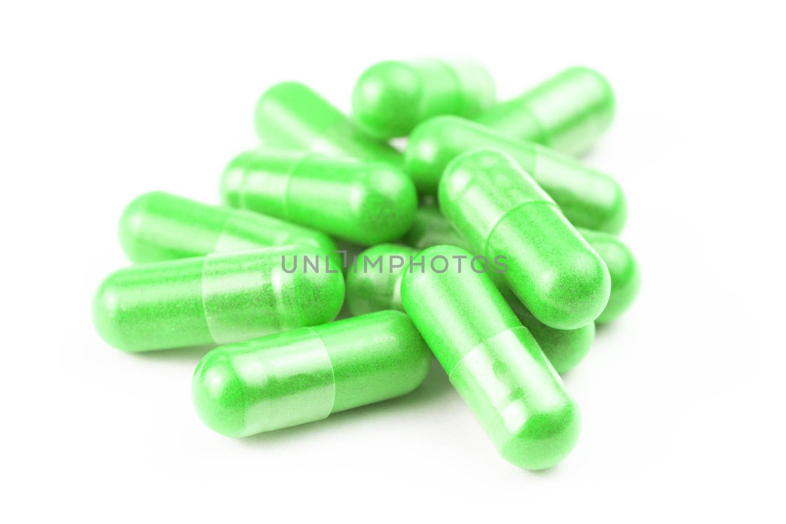 pile of ufo green organic capsules isolated on white background closeup with selective focus.