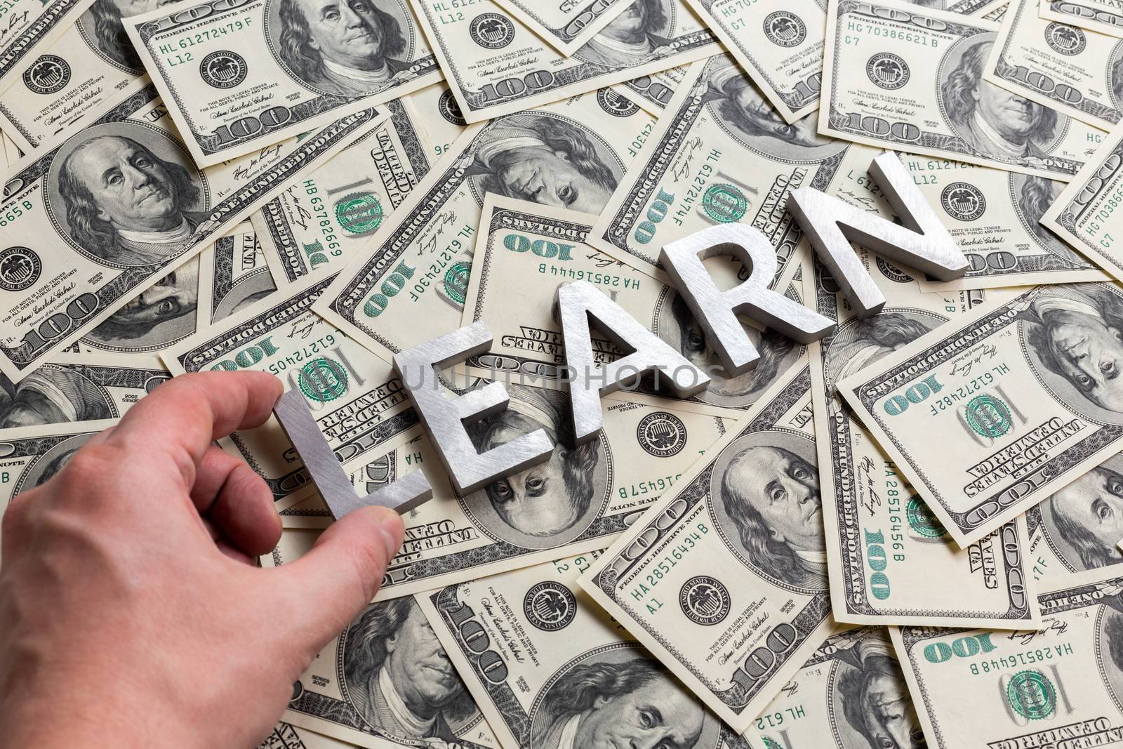 learn to earn - concept made of aluminium characters laid on us monay background