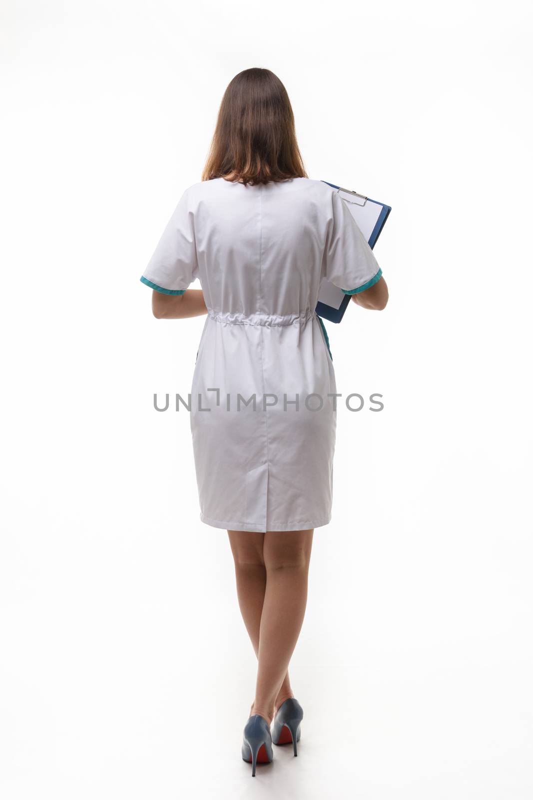 A girl in medical clothing stands back nwa back background