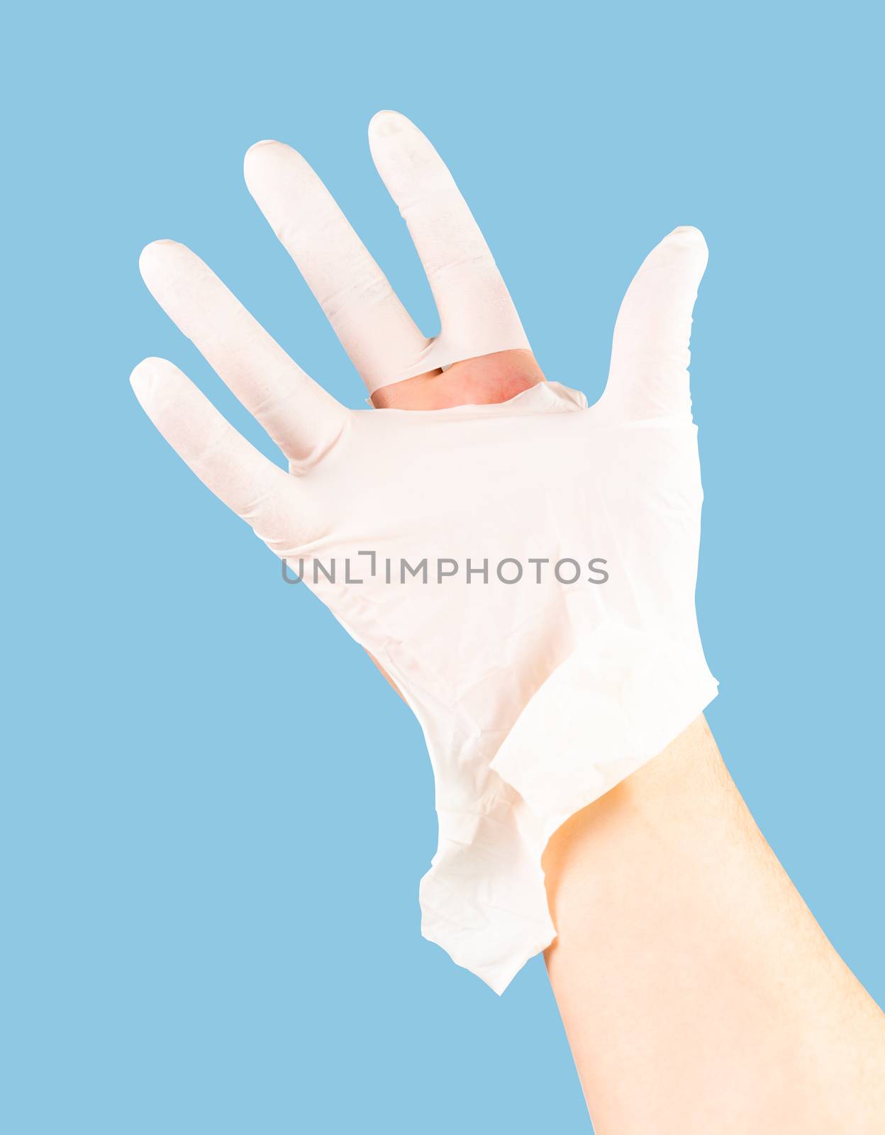 broken white latex surgeon medical glove on caucasian hand isolated on blue monocolor background.