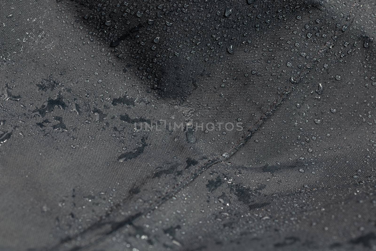 dark gray waterproof hydrophobic cloth closeup with rain drops selective focus background by z1b