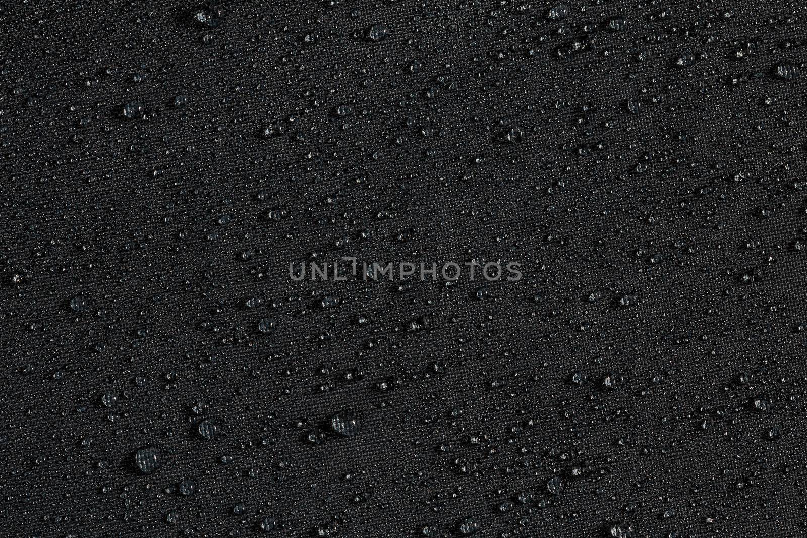 dark gray waterproof hydrophobic flat cloth closeup with water drops background.