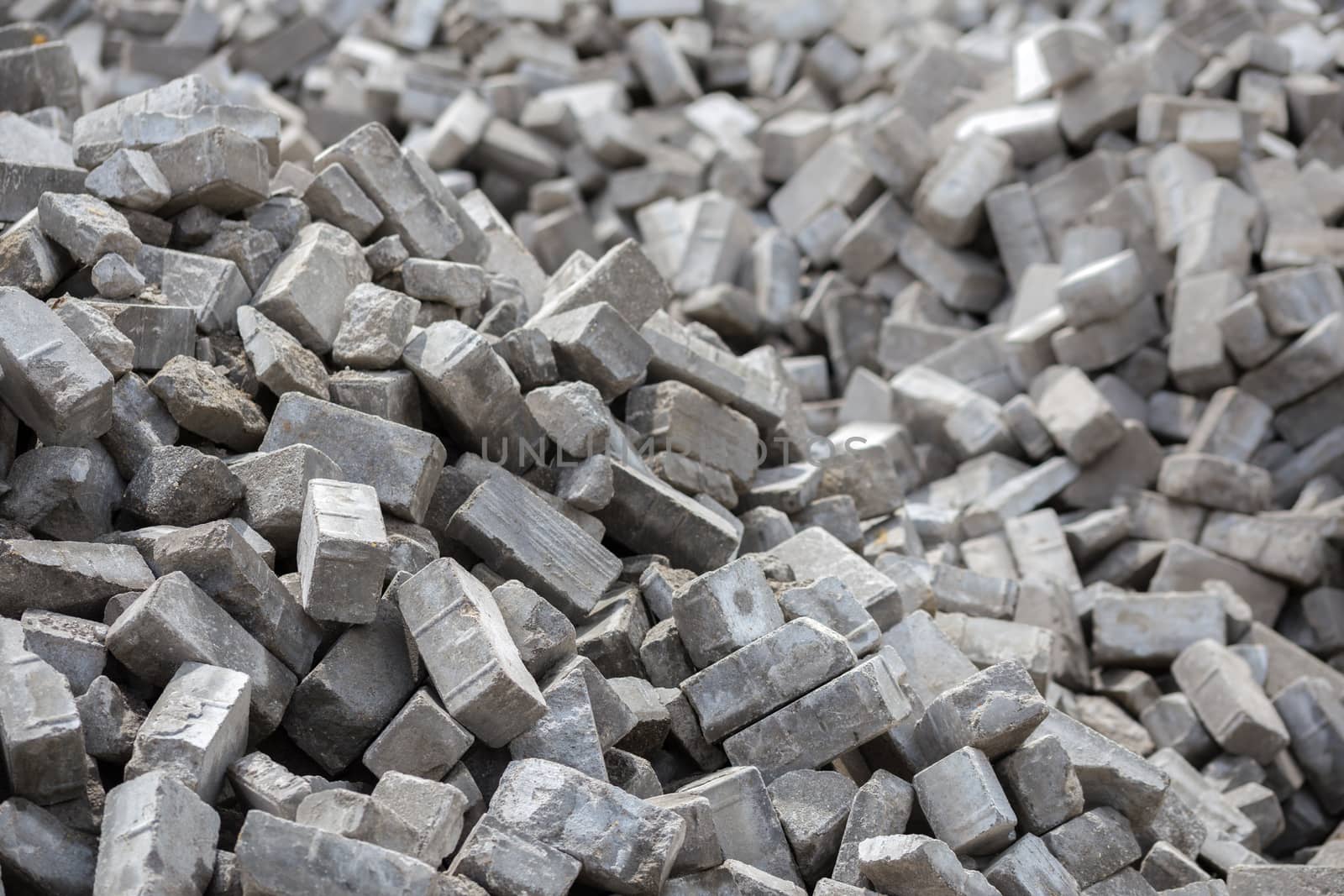 Pile of dismounted gray modern urban pavement bricks with selective focus. Result of russian government corruption in city infrastructure renovation.