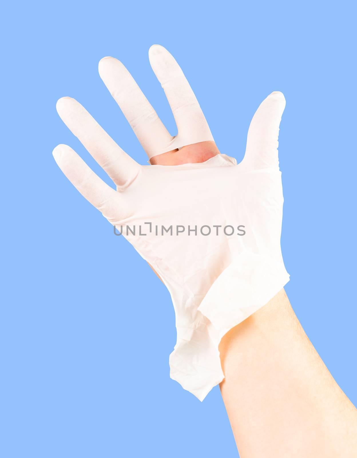 broken white latex surgeon medical glove on caucasian hand isolated on blue monocolor background.
