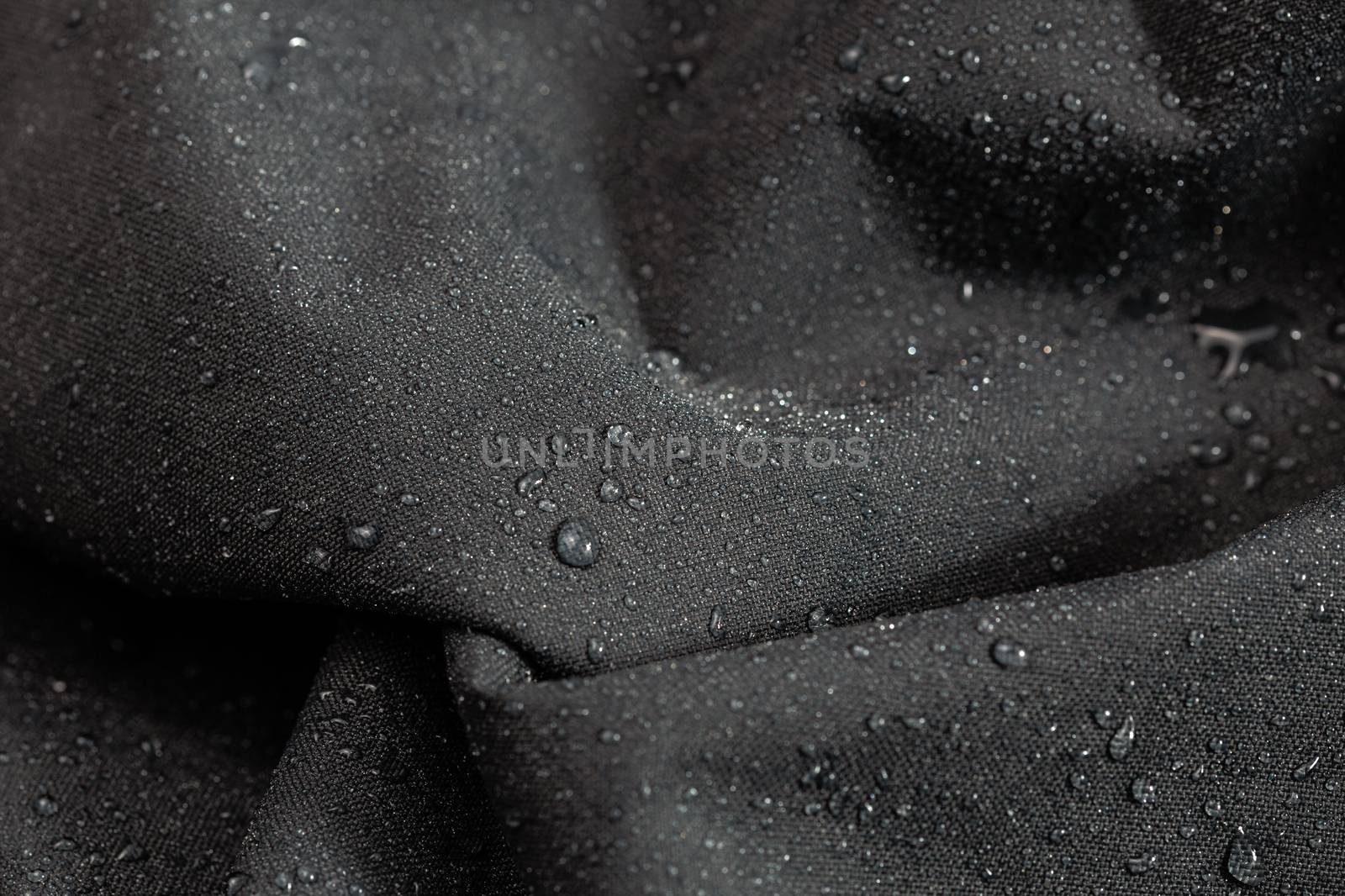 dark gray waterproof hydrophobic cloth closeup with rain drops selective focus background by z1b