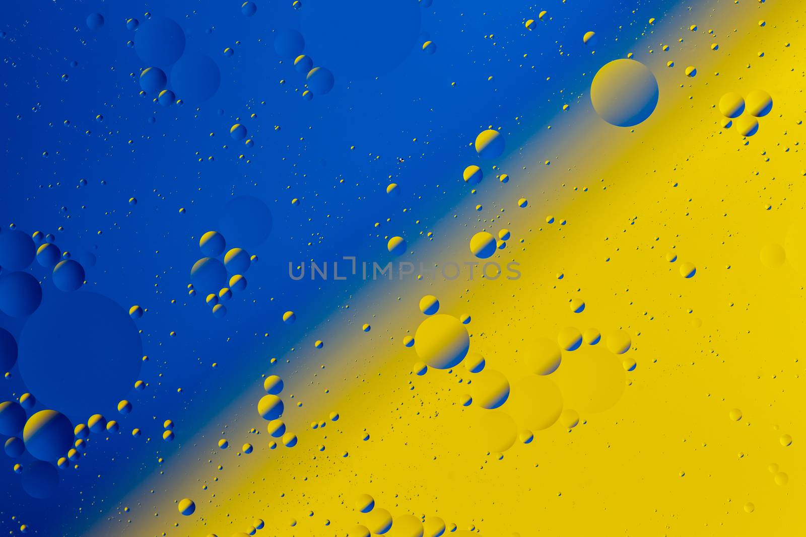 Oil on water flat colorful duotone macro abstract background photographic image. Blue-yellow Ukrainian national theme.