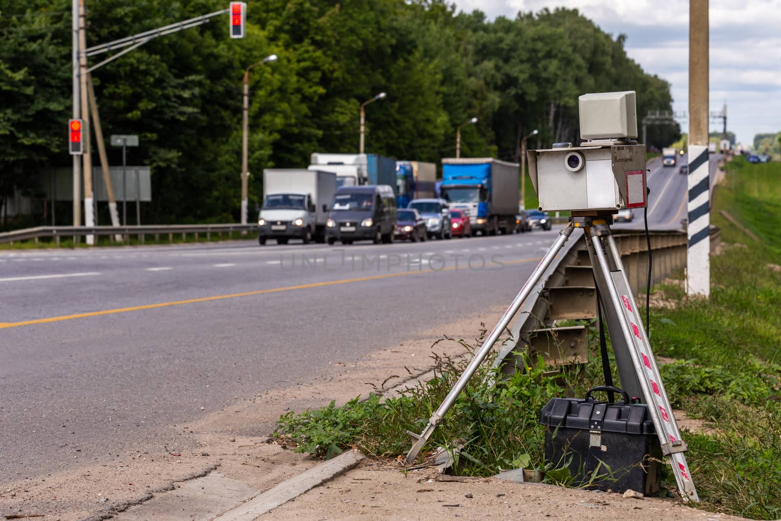 mobile speed camera device on tripod working on summer daytime road with selective focus