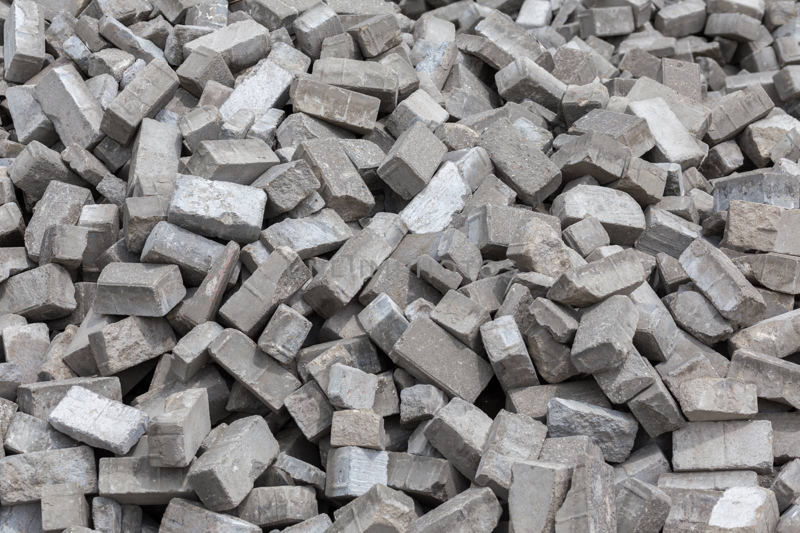 Pile of dismounted gray modern urban pavement bricks with selective focus. Result of russian government corruption in city infrastructure renovation.