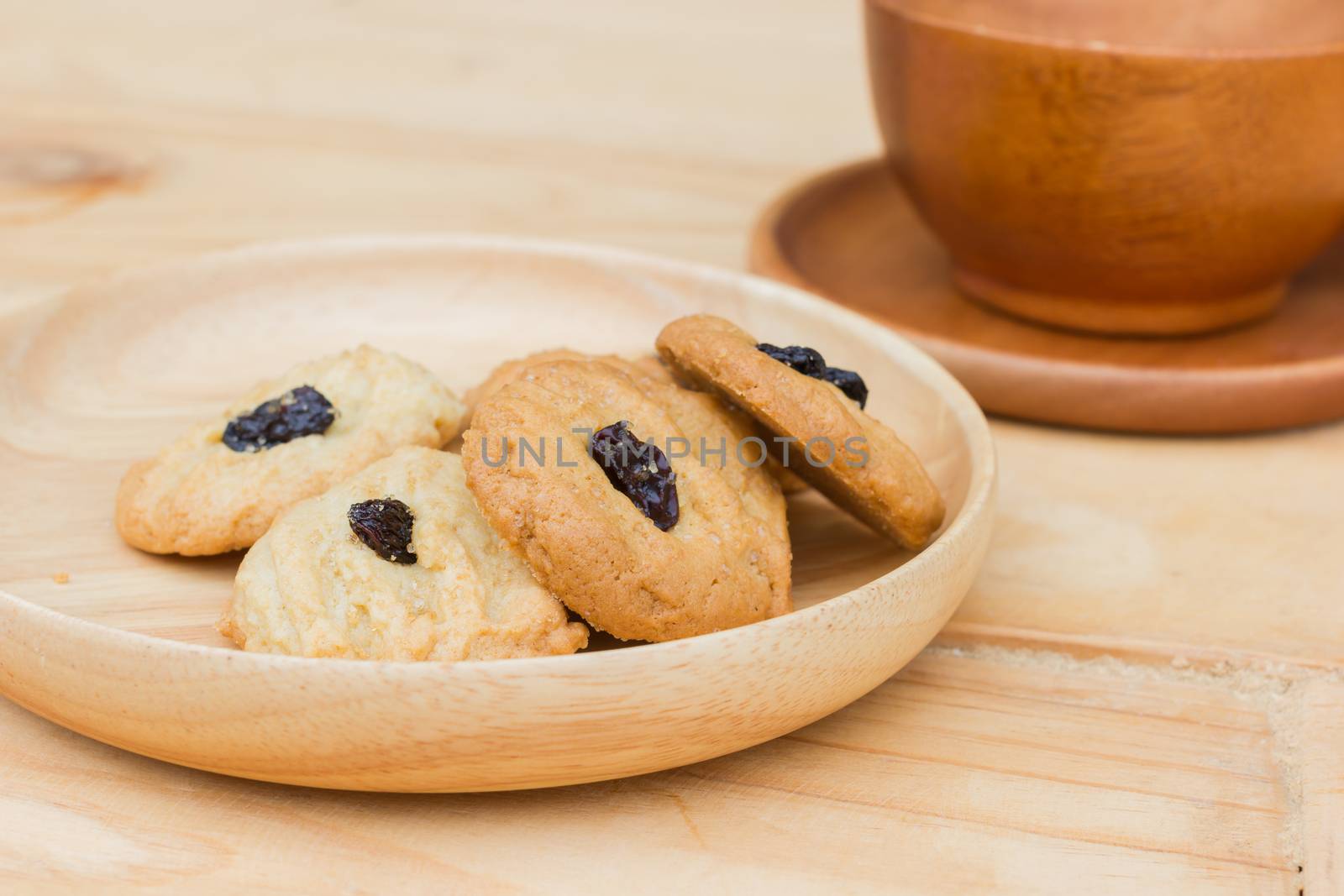 Fresh baked butter cookies with raisins on wooden background