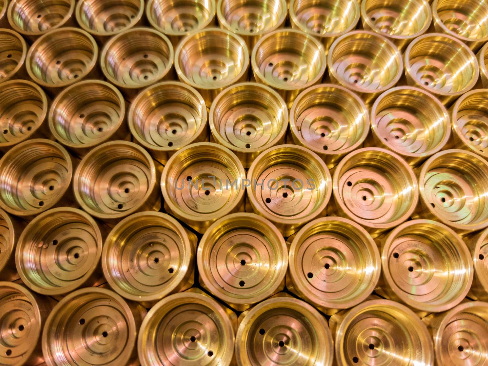 an abstract perspective industrial close-up background of shiny brass metal threaded hexagonal fitting parts.