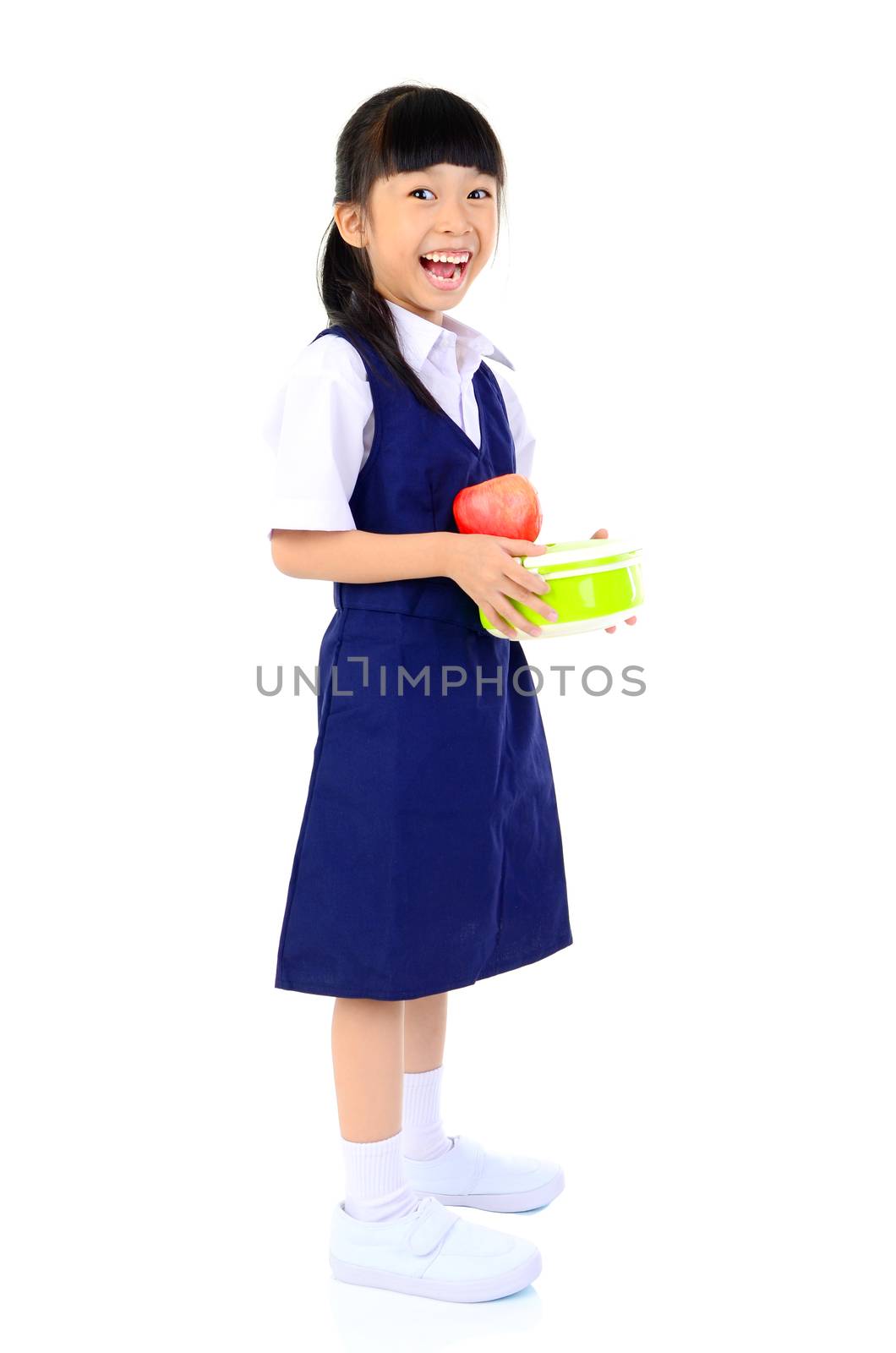 Asian primary school girl holding lunch box. Healthy eating concept for schoolchild.