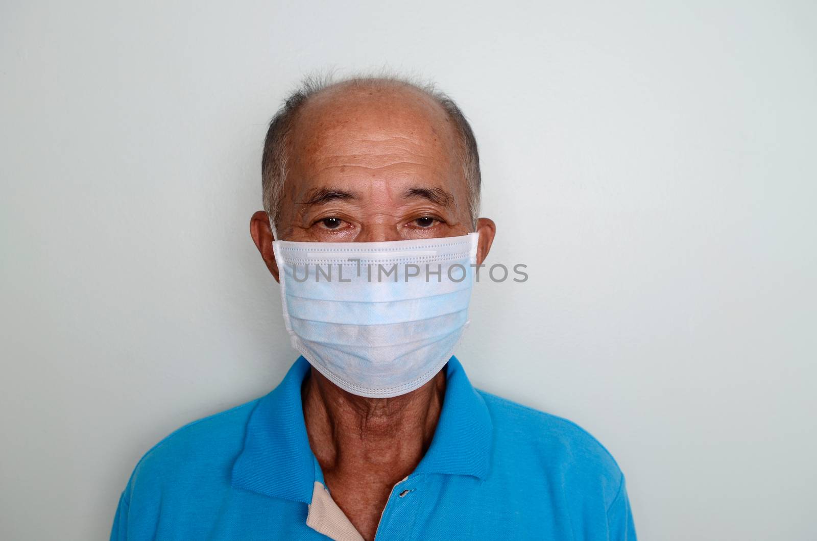 Portrait of an asian senior man, 60 years old wearing medical mask. A concept of the danger of coronavirus for the elderly.