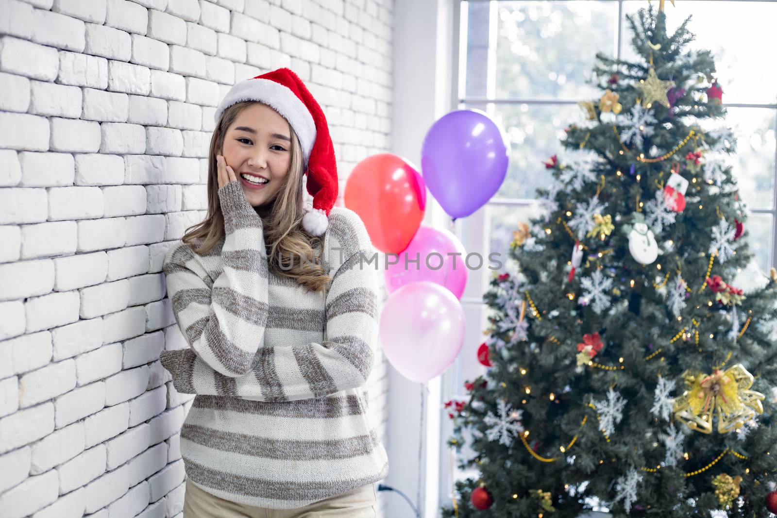Portrait cute Asian young woman in costume Christmas and wear red santa claus hat with smile and theme Christmas background in the home, copy space. Teen woman with celebrate Christmas.