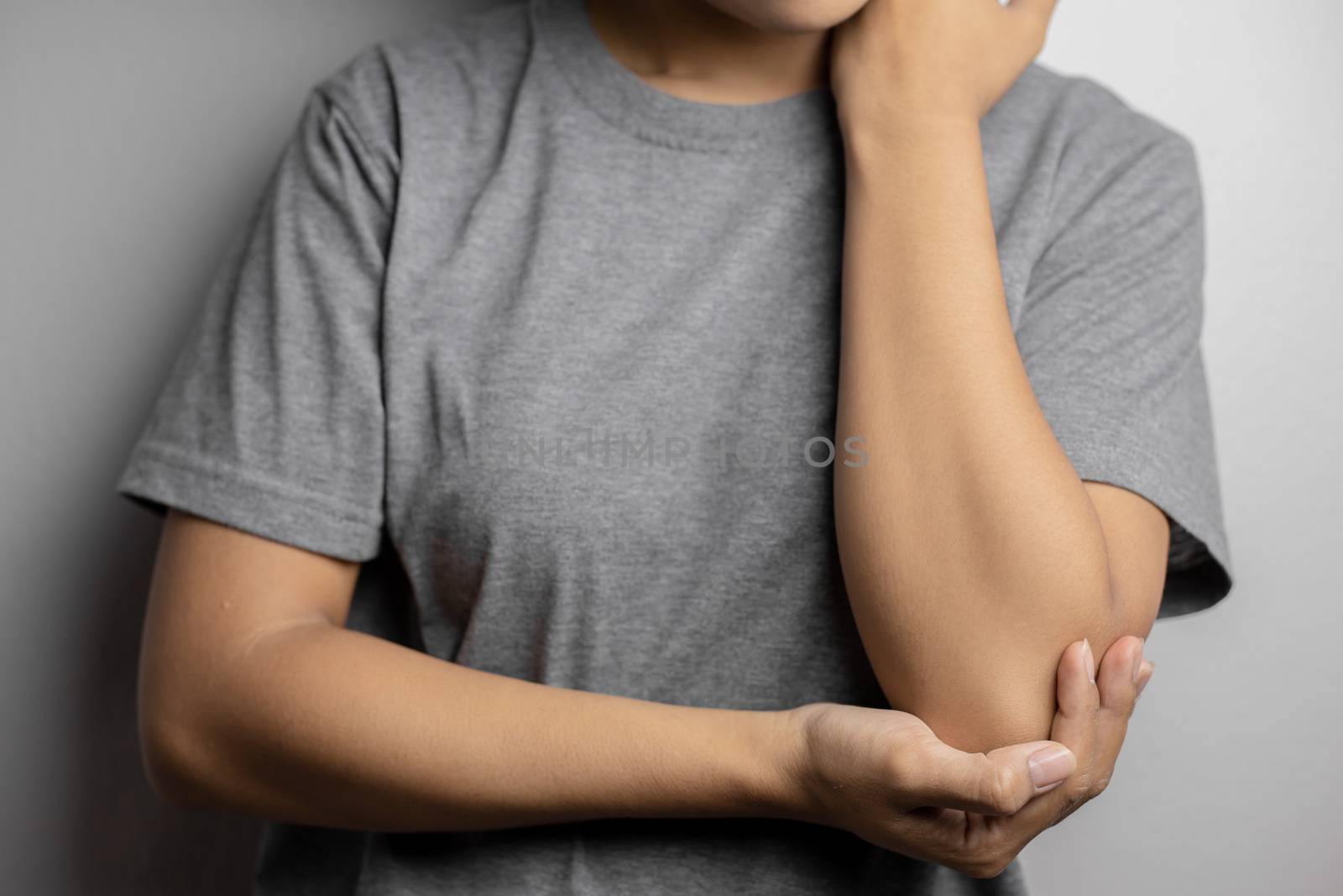 Women with pain in elbow. Acute pain in a elbow. Young woman holds on to elbow.