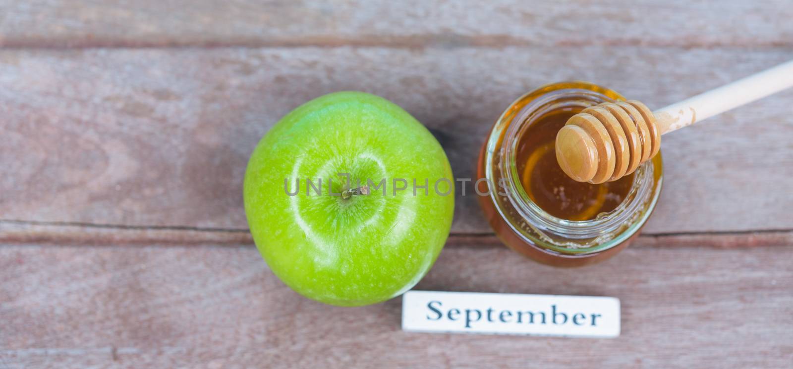 Jewish holiday, Apples Rosh Hashanah on the photo have honey in jar have green apples on wooden background