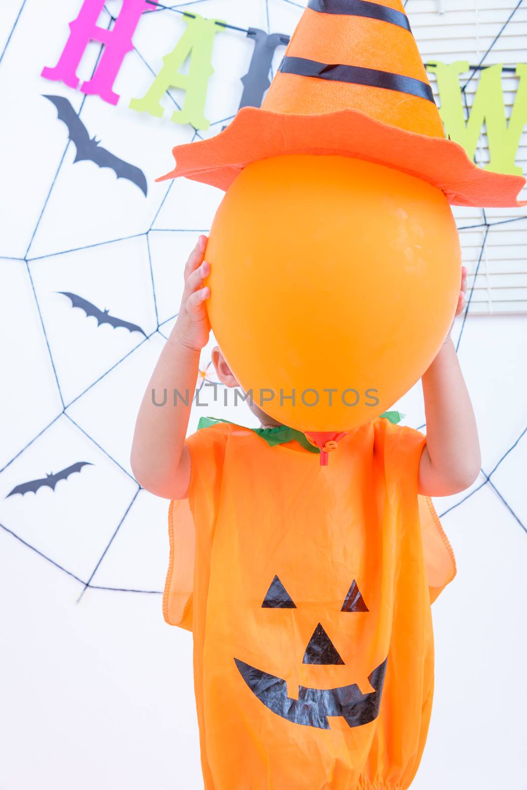 Funny happy kid boy in Halloween costume with Jack and have oran by Sorapop