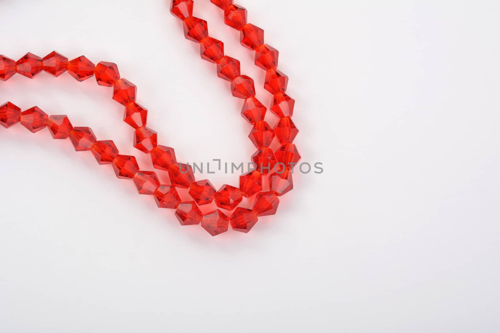 Beautiful Red scarlet, ruby Glass Sparkle Crystal Isoalted Beads on white background. Use for diy beaded jewelry. Space for text