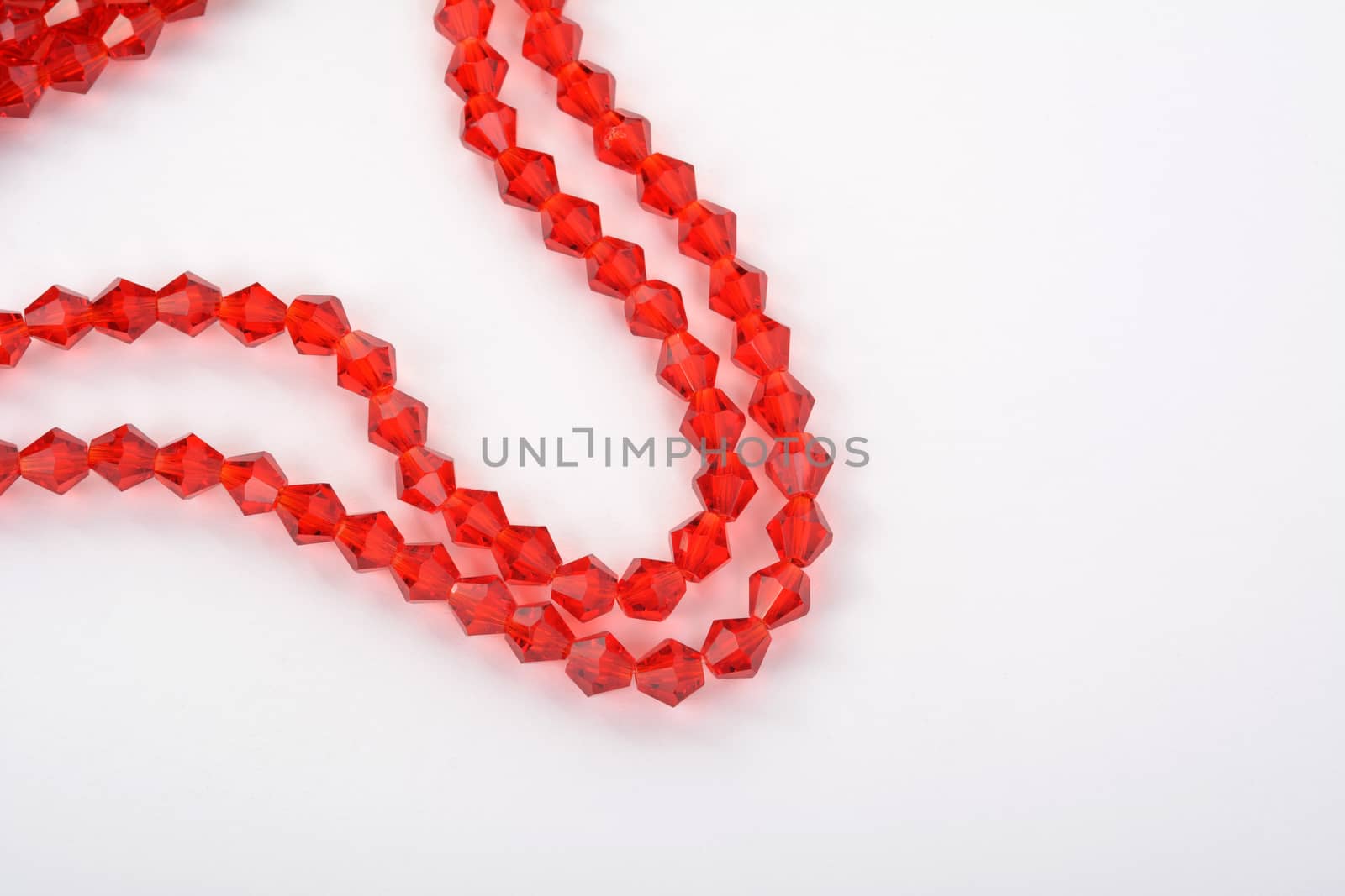 Beautiful Red scarlet, ruby Glass Sparkle Crystal Isoalted Beads on white background. Use for diy beaded jewelry. Space for text