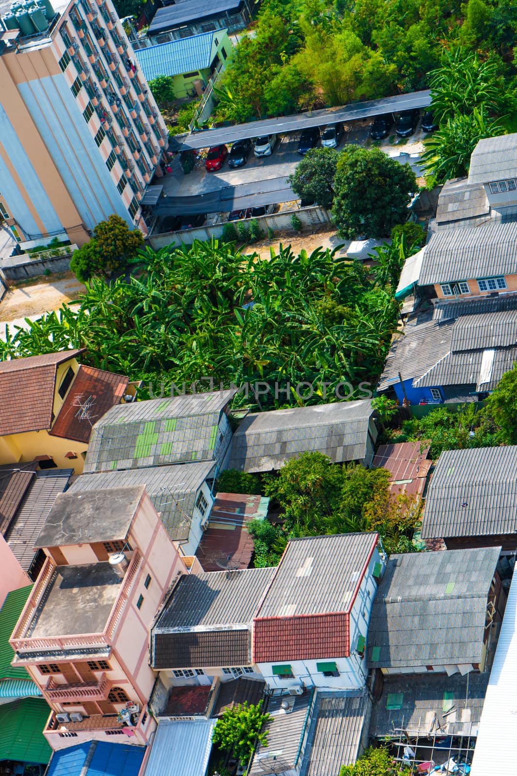 View from the high floor of the streets of Bangkok. Tall buildings and roofs of small houses. City landscape.