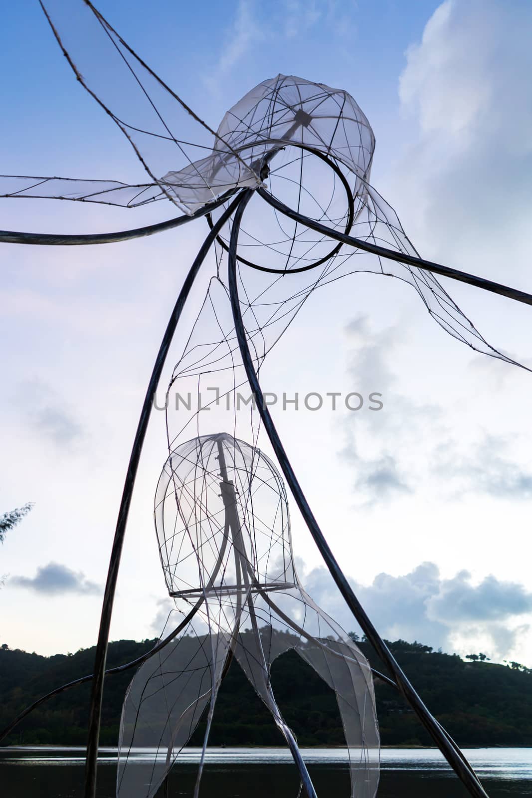 Figures of jellyfish on a background of a sunset sky..