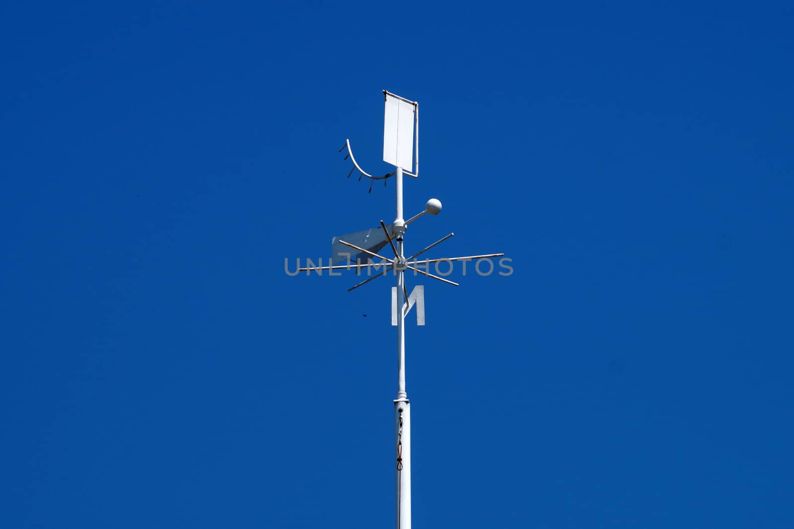 weather station weather vane close-up on a background of clear blue sky by Annado