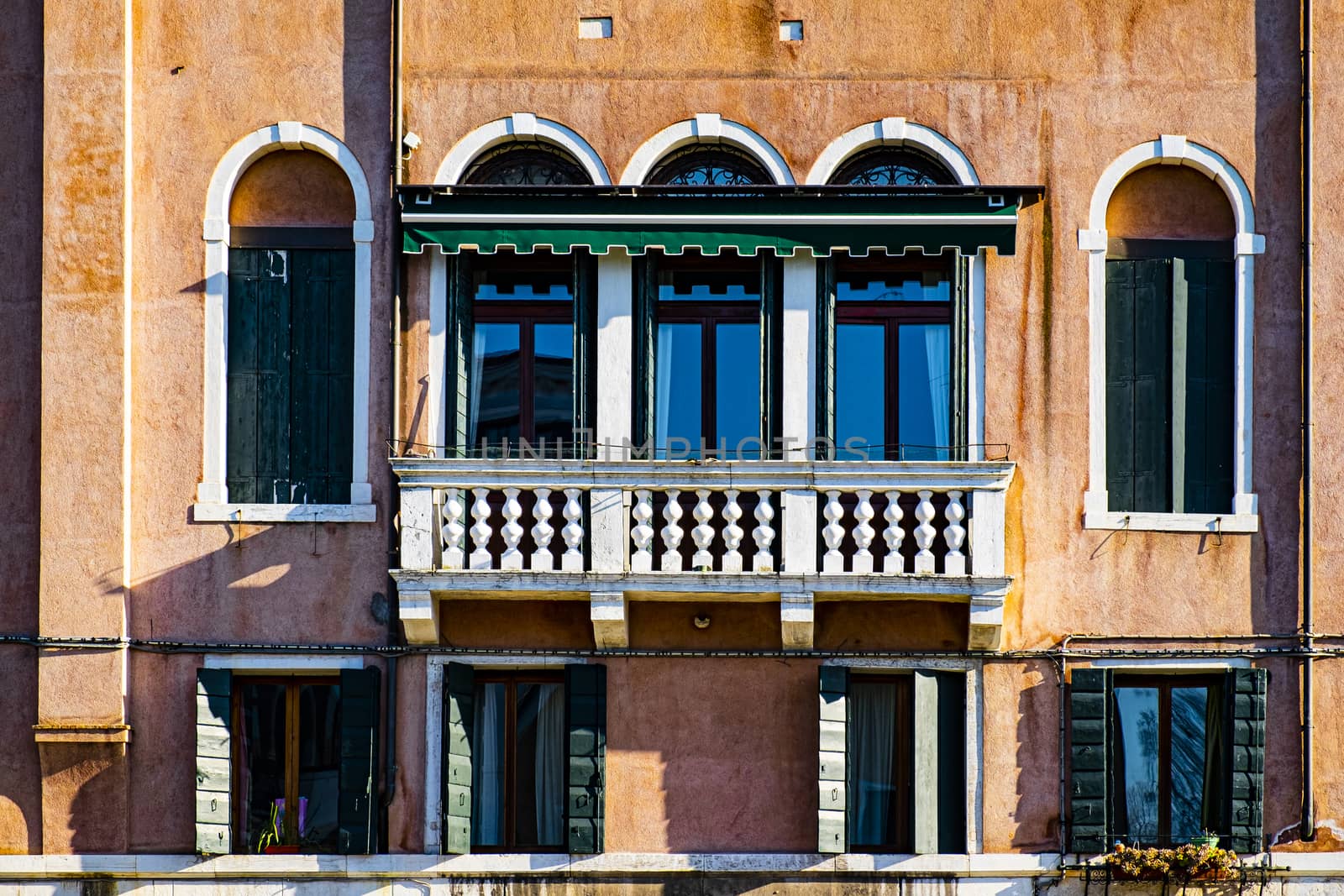Italian culture on Venetian facades. Venice is rich and poor, well-groomed and abandoned, reflected in its windows.