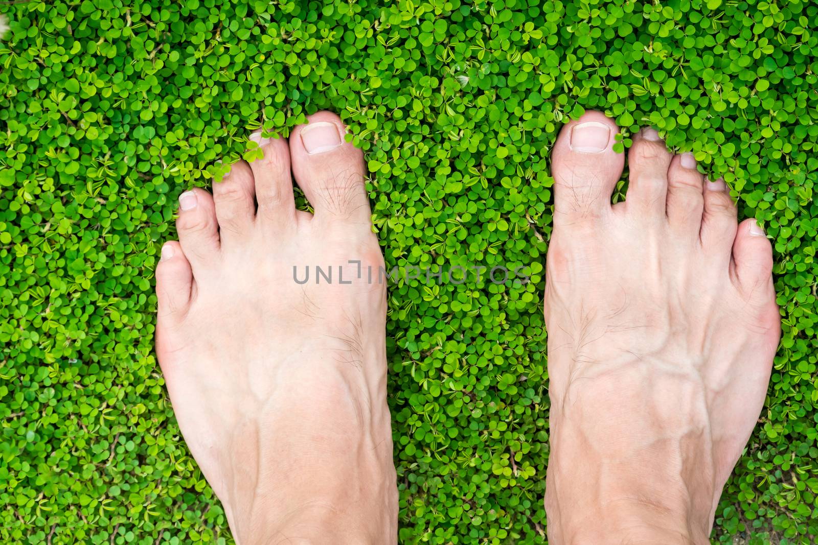 man's feet standing on grass by somesense