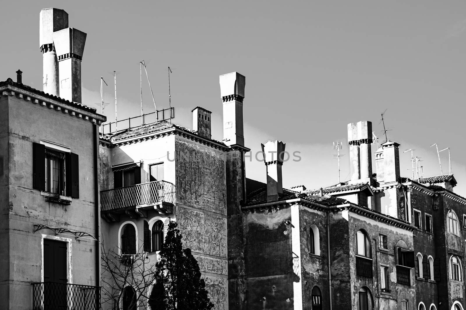 Italian culture on Venetian facades in black and white. Venice is rich and poor, well-groomed and abandoned, reflected in its windows.