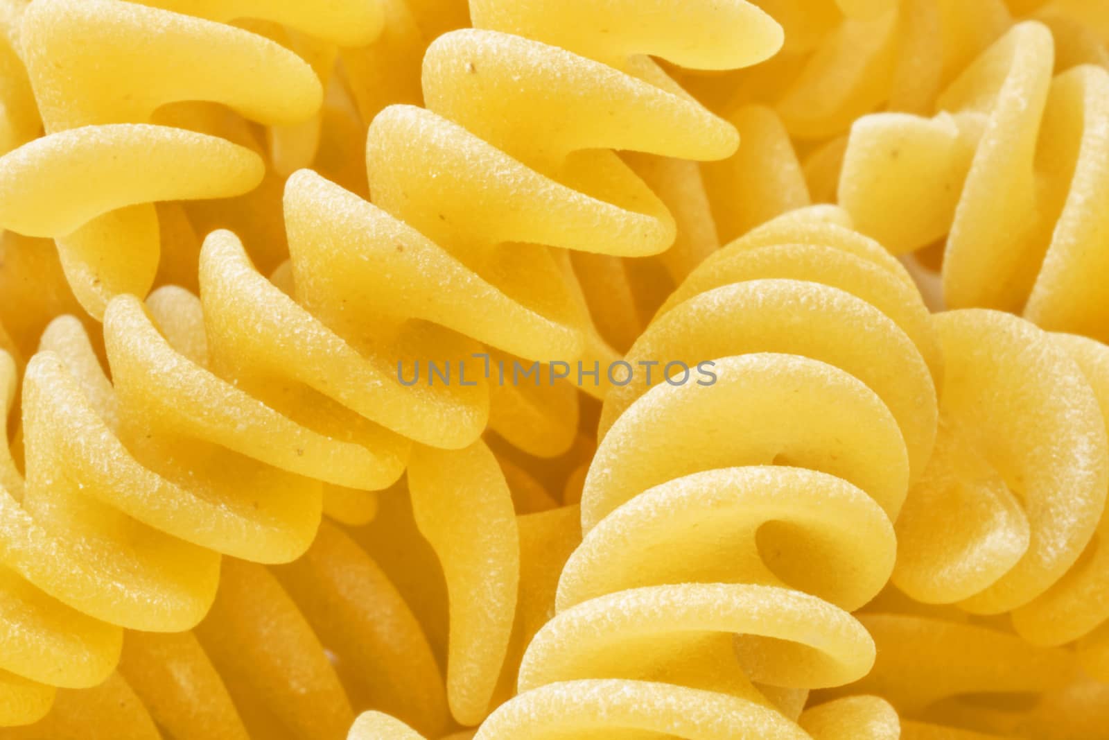 Italian pasta called fusilli ,  helical shape pasta, studio shot ,full frame , macro photography , high contrast