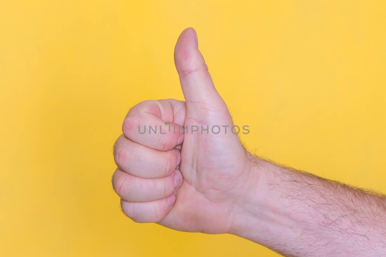 thumb up sign on yellow background by Iryna_Melnyk