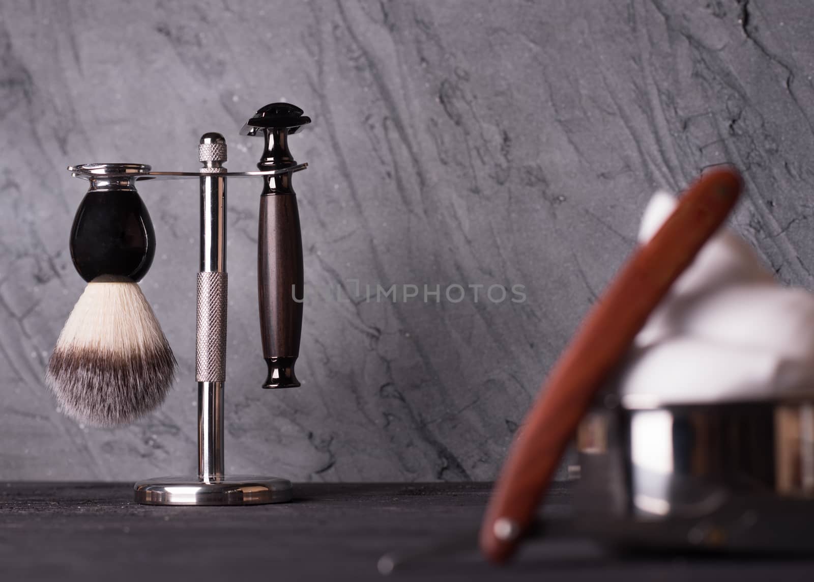 Razor, brush, and perfume on a wooden background.